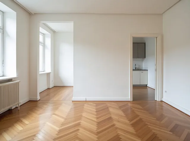 Leere, saubere Münchner Wohnung mit Fischgrätparkett und hellen Wänden, bereit für die Übergabe – Endreinigung München